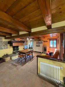 a large living room with a table and a fireplace at Casa Vacanze MULINO DI VALIANA in Pratovecchio +10 photos