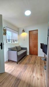 a living room with a bed and a wooden door at Beautiful Independent House in Punta Arenas