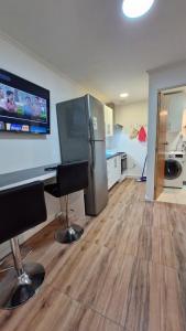 a kitchen with a refrigerator and two chairs in a room at Beautiful Independent House in Punta Arenas