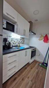 a kitchen with white cabinets and a sink and a stove at Beautiful Independent House in Punta Arenas