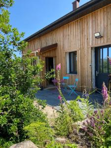 a cottage with a patio and flowers at Lysgaardcottage 360 sauna spa bar Dancing 25V in La Bresse