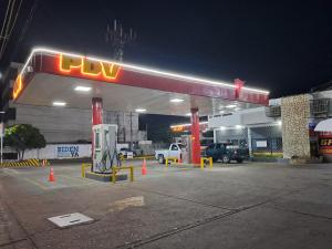 a uvy gas station at night with cars parked at Apto Comodo cerca de Centro de Puerto La Cruz in Puerto La Cruz