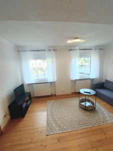 a living room with a blue couch and a table at Ferienwohnung auf Hof Santangelo in Dickesbach