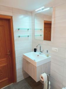 a white bathroom with a sink and a mirror at Gemütliche Ferienwohnung auf Hof Santangelo in Dickesbach +14 photos