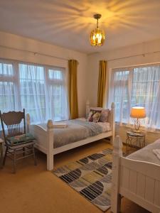 ein Schlafzimmer mit einem Bett und einem Stuhl und Fenstern in der Unterkunft Cable Island Bed and Breakfast in Cork
