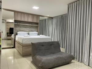 a bedroom with a bed and a chair at Lounge 22 barato 12e13agosto in Goiânia +35 photos