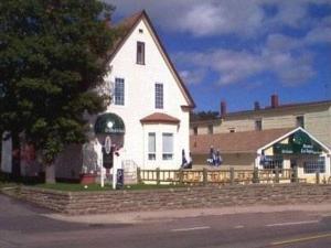 una gran casa blanca con una valla delante en Le Gîte De La Sagouine, en Bouctouche