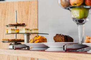 a table with cakes and other desserts on plates at Neco Boutique Hotel in San Bernardo