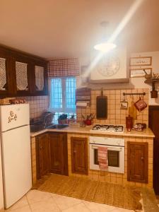 a kitchen with a white stove and a refrigerator at La Casa di Vale in Marano Equo