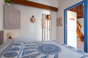 a bedroom with a bed with a blue and white bedspread at La Casa Di Benedetta in Portiragnes