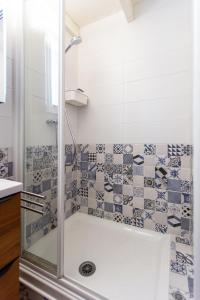 a bathroom with a shower with blue and white tiles at La Casa Di Benedetta in Portiragnes +19 photos