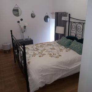 a bedroom with a black bed with a white comforter at maison calme et campagne in Le Pin-la-Garenne