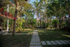 a path in a park with trees and a fence at Laoxao RiverStone Villa in Hoi An