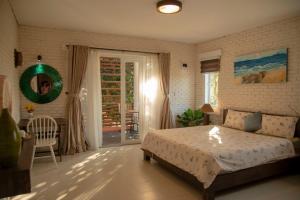 a bedroom with a bed and a sliding glass door at Laoxao RiverStone Villa in Hoi An +52 photos