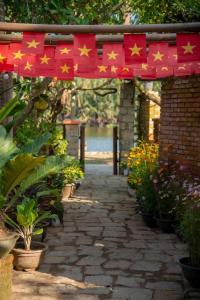 einen Weg mit roten Flaggen mit Sternen darauf in der Unterkunft Laoxao RiverStone Villa in Hoi An