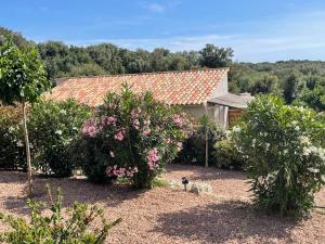 a house with a garden with trees and flowers at Résidence Patios di Pruno CAPITELLO in Figari
