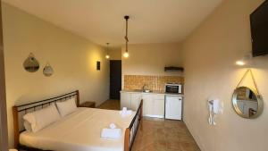 a bedroom with a large bed and a kitchen at Georgia's House Project in Skiathos