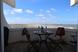 a table and chairs with a view of the ocean at BBA Appartement climatisé vue mer Baleal in Ferrel