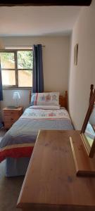 a bedroom with a bed and a wooden table at The Dairy in Teignmouth