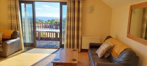 a living room with a couch and a view of a balcony at The Dairy in Teignmouth