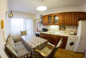a kitchen with a table and chairs and a refrigerator at Vándor Vendégház in Szeged