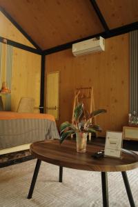 ein Zimmer mit einem Tisch, auf dem eine Pflanze steht in der Unterkunft Baanraisongshul K&E Gardens in Khlong Lan + 17 Fotos
