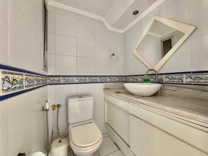 a bathroom with a toilet and a sink and a mirror at Apartamento a beira-mar in Capão da Canoa +3 photos
