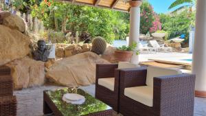 a patio with chairs and a table and a statue at B&B Il Resort Dell'Artista in Venetico