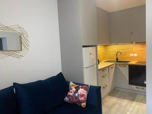 a living room with a couch and a kitchen at APARTAMENT PLUS in Włodawa