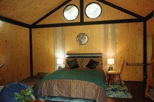 ein Schlafzimmer mit einem Bett in einem Zimmer mit zwei Fenstern in der Unterkunft Baanraisongshul K&E Gardens in Khlong Lan