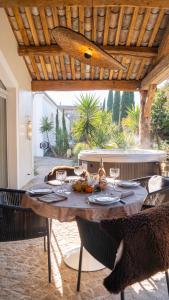 a table with food and wine glasses on a patio at Secret d'Uzès - Place aux Herbes - Piscine chauffée et Jacuzzi in Uzès