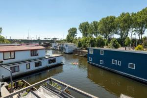 Un río con casas y un barco en el agua en NOVA Houseboat DELUXE Free Bikes, en Ámsterdam