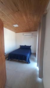 a bedroom with a blue bed and a wooden ceiling at JeiDanApart alojamiento in Puerto Iguazú