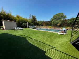 a backyard with a swimming pool and a lawn at Le clos Mirondin in Six-Fours-les-Plages