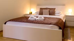 een slaapkamer met een groot bed en handdoeken bij Apartment Centro in Belgrado