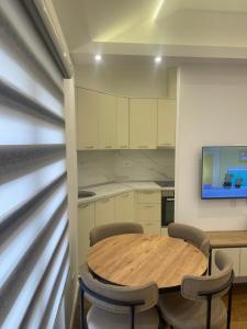 a kitchen with a wooden table and chairs at Apartman Sofija Zagoric in Podgorica