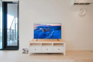 un salon avec une télévision sur un mur blanc dans l'établissement Luxury Apartment in Rundle Mall with Beautiful City Views, à Adélaïde 12 autres photos