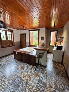a kitchen with a island in a room with a wooden ceiling at Chalés Lavras de Minas - Amar in Lavras Novas +20 photos