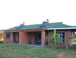 a brick house with solar panels on the roof at BELA Vic in Bela-Bela