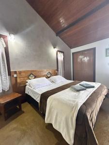 a bedroom with a large bed in a room at Chalés Lavras de Minas - Brasil in Lavras Novas