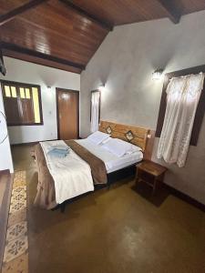 a bedroom with a large bed in a room at Chalés Lavras de Minas - Brasil in Lavras Novas +18 photos
