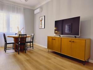 a living room with a table and a television on a cabinet at Civico 34 Urban House in Ciampino