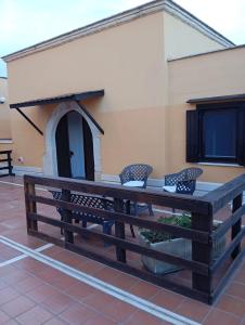 a large wooden table with chairs in front of a building at Casal Mastro appartamenti e camere con piscina in Bisceglie