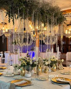 a table with chandeliers and flowers on it at Alojamiento RBOY Las Mariposas in Chillán