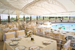 a banquet hall with tables and a swimming pool at Plavnica Eco Resort in Virpazar