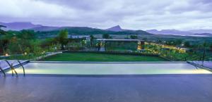 a balcony with a view of a garden at night at Amour Resort & Spa Pawana in Kolvan