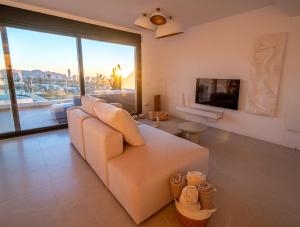 un salon avec un canapé blanc et une télévision dans l'établissement BENIDORM Amber Stay, à Finestrat