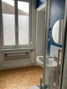 a bathroom with a sink and a window at Maison Dentelle in Caudry
