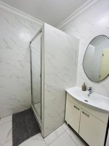 biała łazienka z umywalką i lustrem w obiekcie Szabo Laszlo Apartman w Hajduszoboszlo
