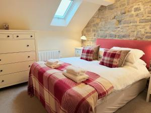 a bedroom with a bed with a red headboard at Standlow Farm in Kniveton